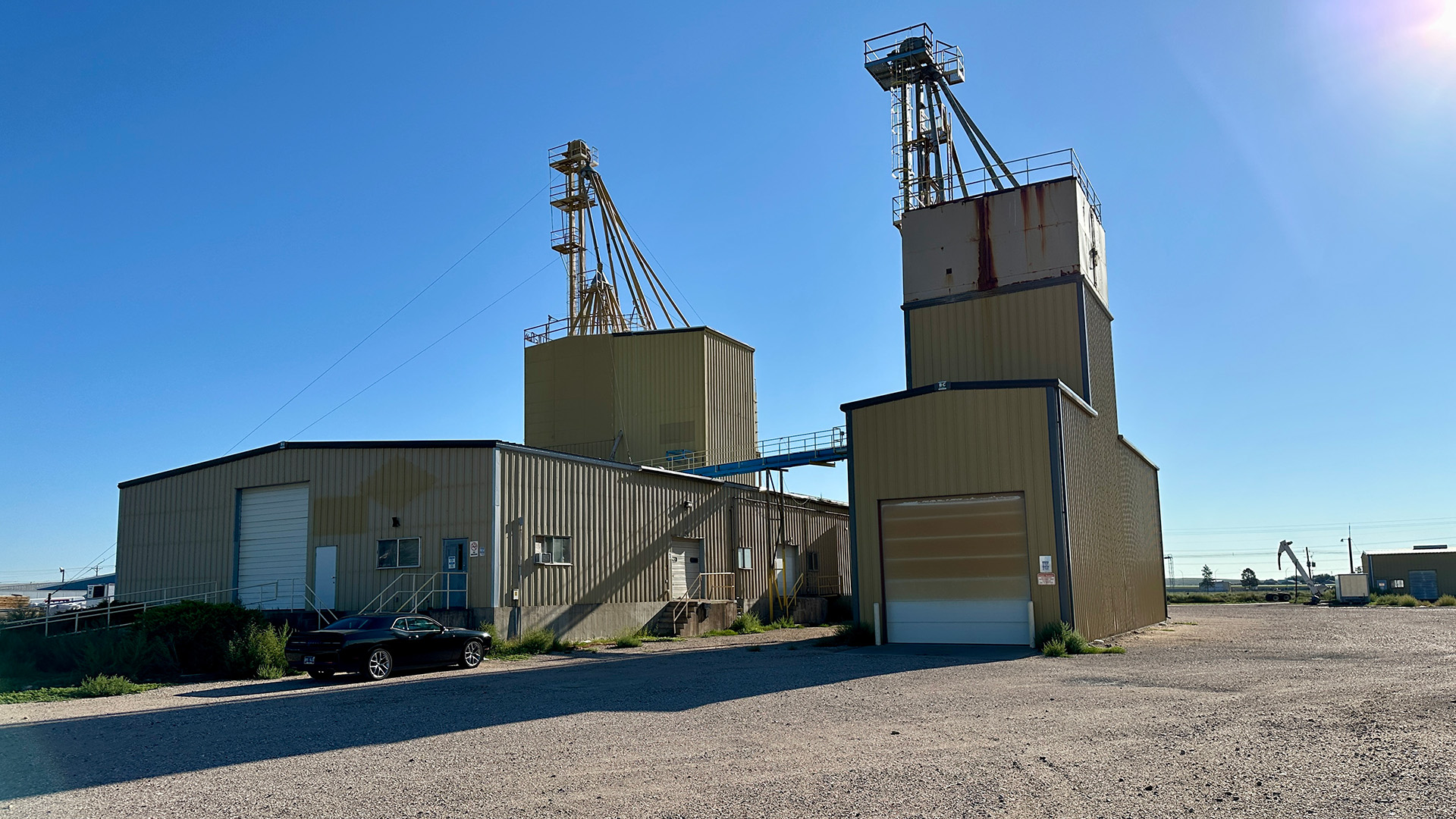 External food production plant with clear blue skies in the background and a dirt road