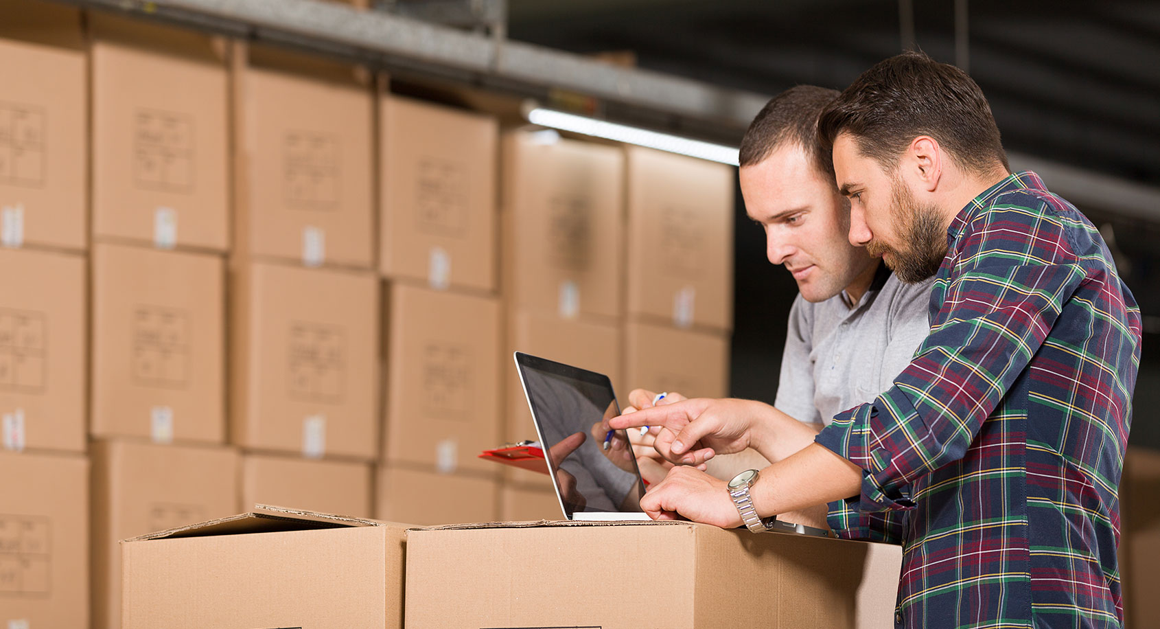 Men looking at computer with boxes