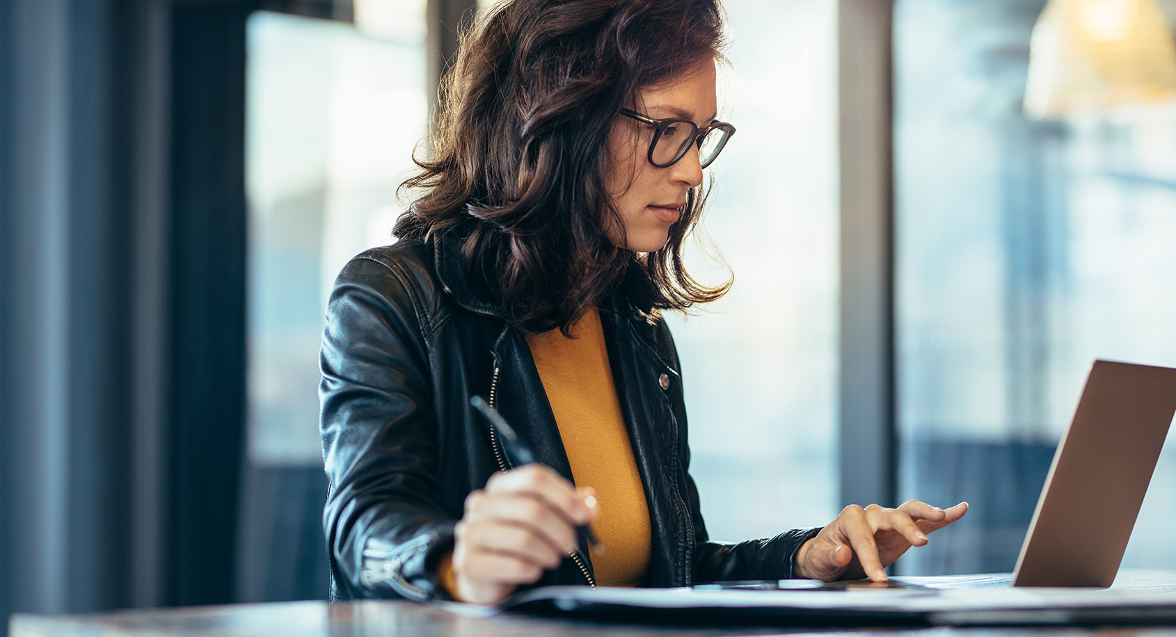Woman in yellow sweater working at a laptop
