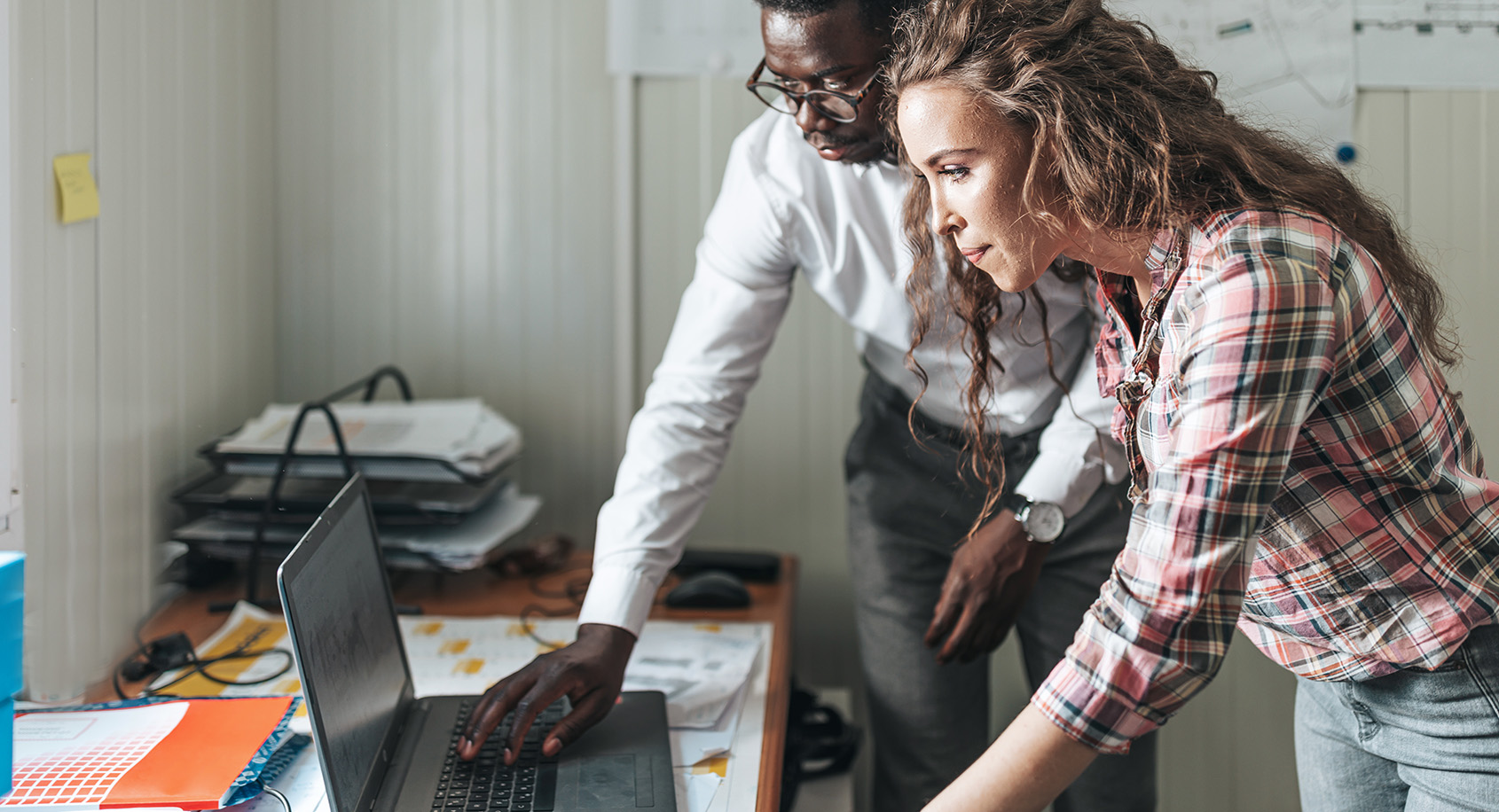 People at a computer looking at blueprints